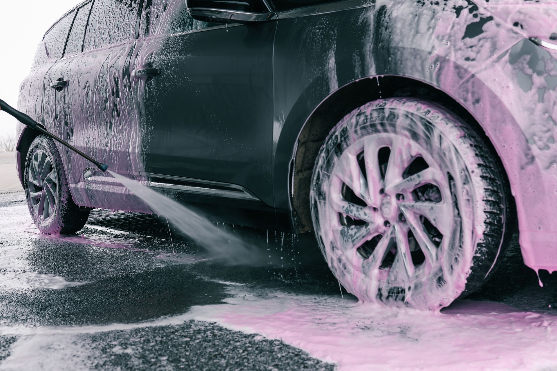 Hand washing car with pink foam, advertising