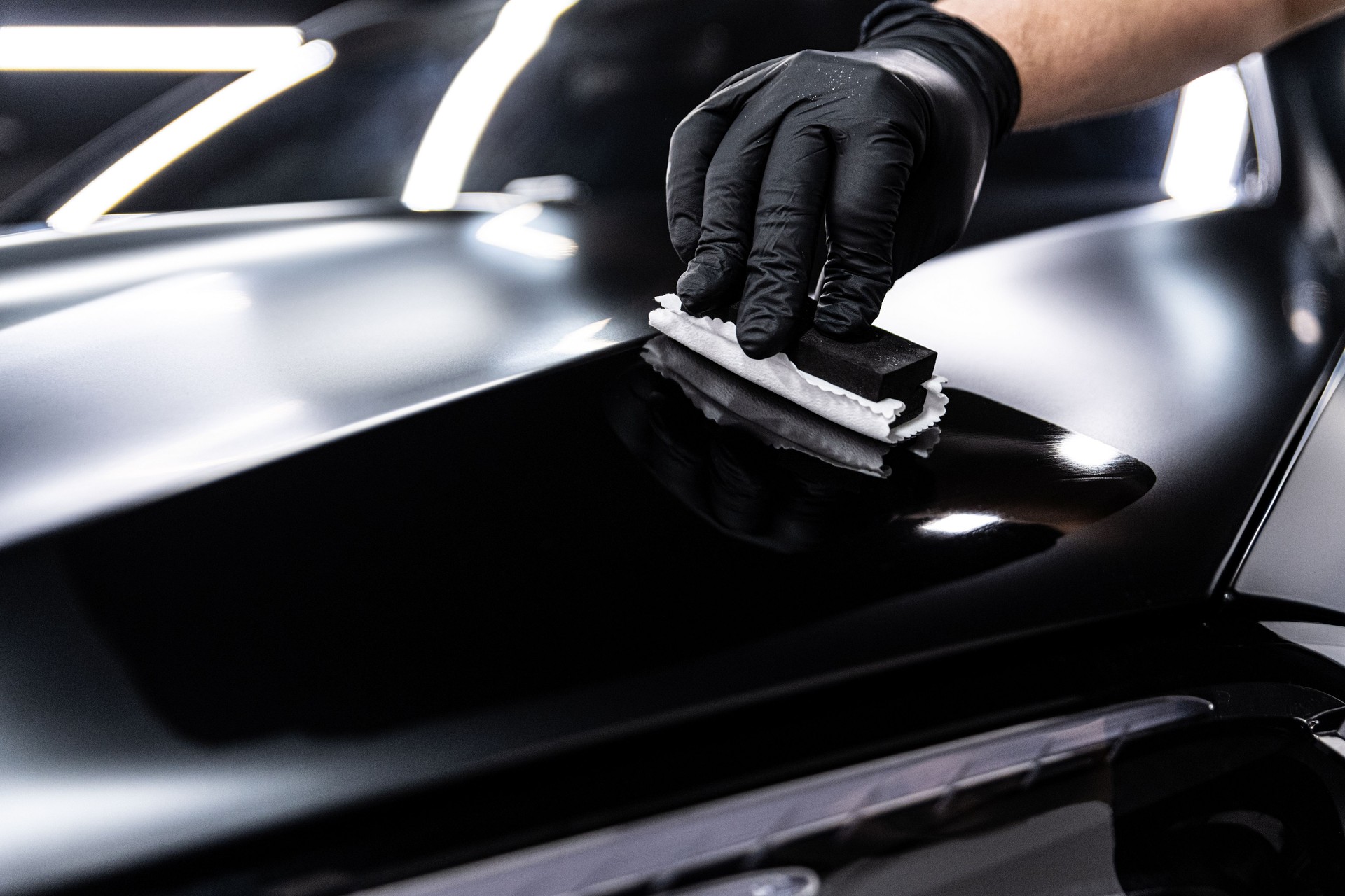 Car wash or detailing employee applies ceramic or graphene coating